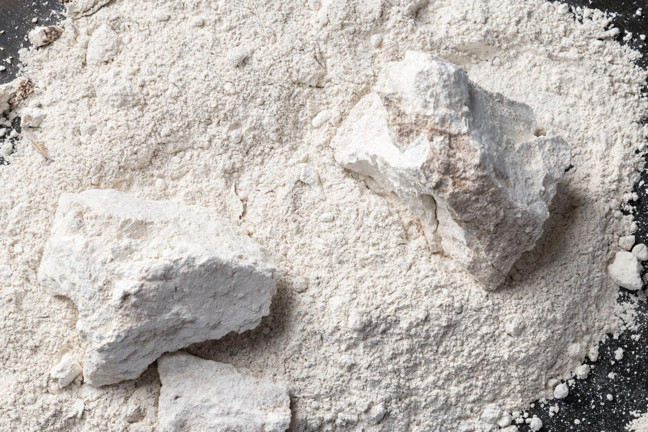 Fragmentos blancos de trípoli sobre una superficie de material pulverizado.